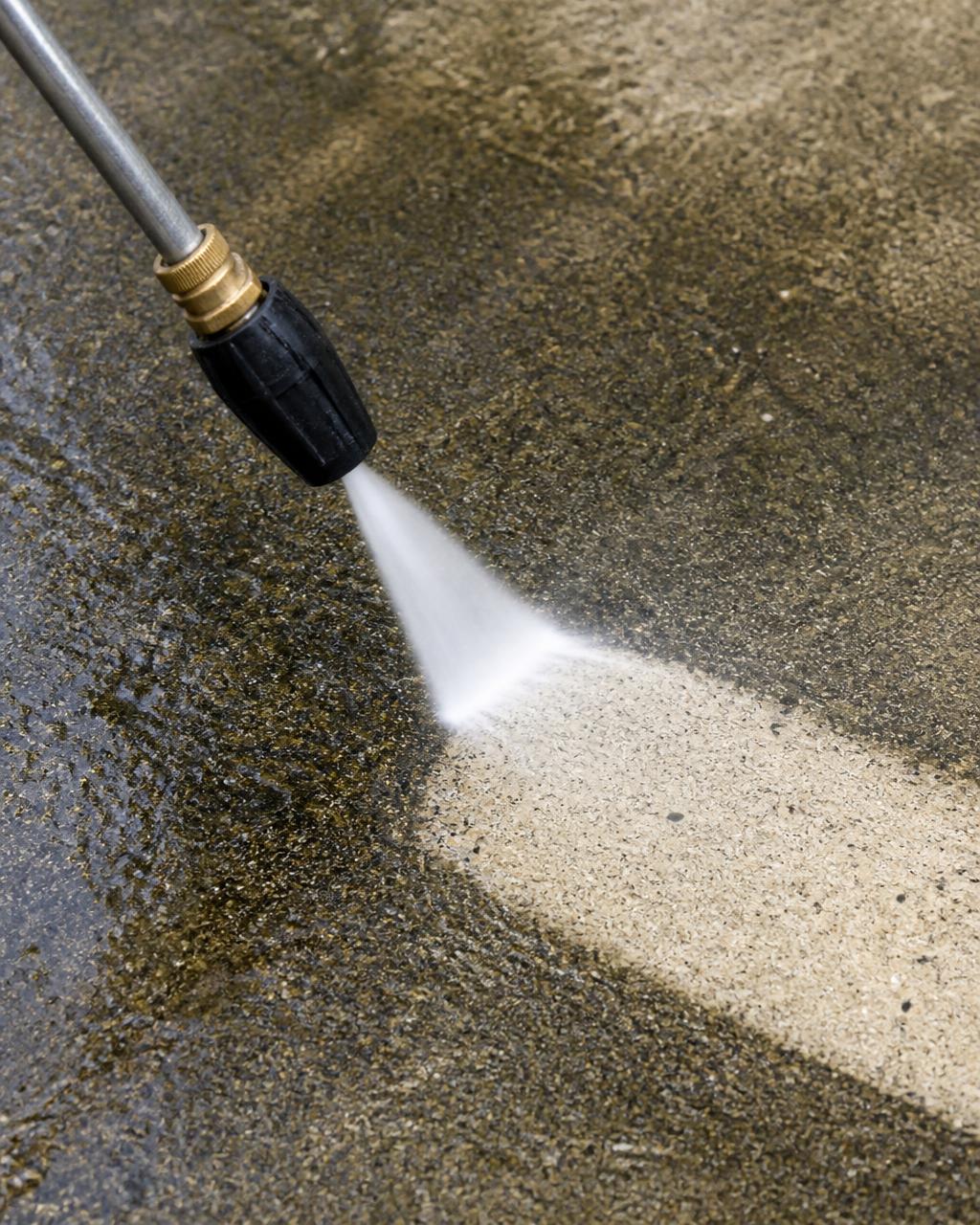 Pressure washer cleaning a dirty concrete driveway